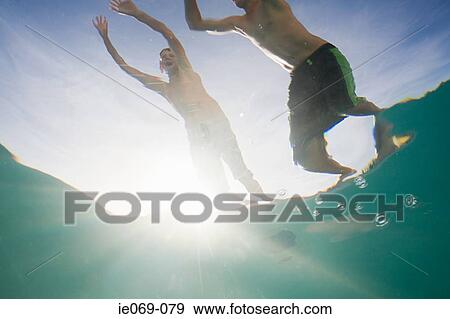 Boys jumping into swimming pool View Large Photo Image Stock Photo - Boys jumping into swimming pool. Fotosearch