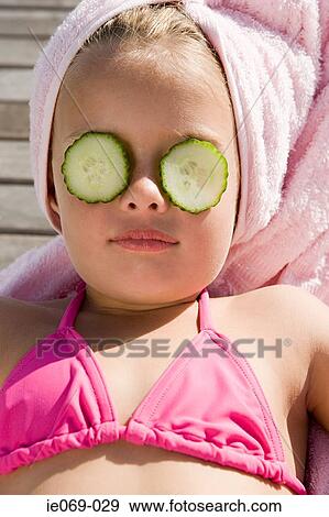 Girl with cucumber slices on her eyes View Large Photo Image Stock Photo - Girl with cucumber slices on her eyes. Fotosearch
