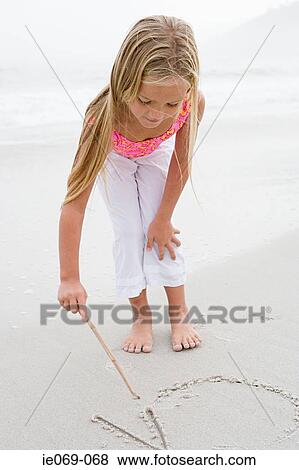 Girl writing on the sand View Large Photo Image Stock Photo - Girl writing on the sand. Fotosearch