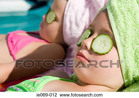 Girls with cucumber slices on eyes View Large Photo Image Stock Image - Girls with cucumber slices on eyes. Fotosearch