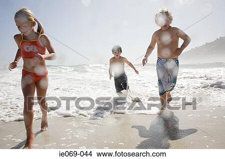 Kids running from waves View Large Photo Image Picture - Kids running from waves. Fotosearch