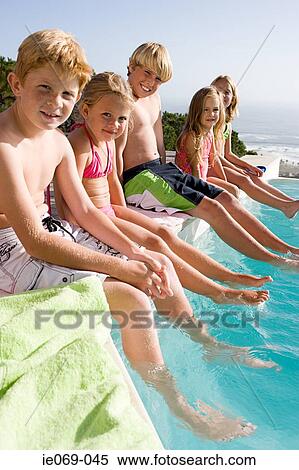 Kids sitting on edge of swimming pool View Large Photo Image Stock Photography - Kids sitting on edge of swimming pool. Fotosearch
