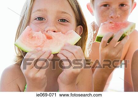 Stock Image - Kids with watermelon slices. Fotosearch