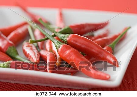 Picture - Red chilli peppers on a dish. Fotosearch