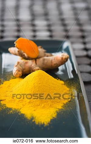 Stock Photograph - Tumeric powder and fresh tumeric. Fotosearch