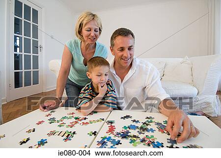 Picture - Family doing a jigsaw puzzle. Fotosearch
