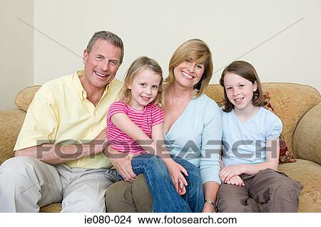 Family sitting on a sofa View Large Photo Image Picture - Family sitting on a sofa. Fotosearch