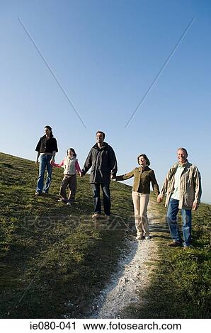 Family walking hand in hand on hill View Large Photo Image Stock Image - Family walking hand in hand on hill. Fotosearch