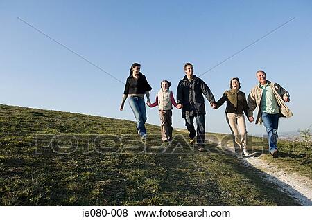 Family walking hand in hand on hill View Large Photo Image Stock Photo - Family walking hand in hand on hill. Fotosearch