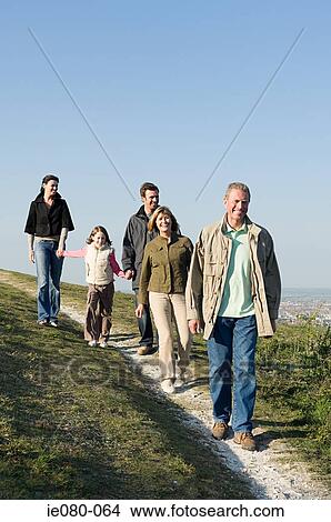 Family walking on grassy hill View Large Photo Image Picture - Family walking on grassy hill. Fotosearch
