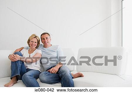 Mature couple relaxing on sofa View Large Photo Image Stock Image - Mature couple relaxing on sofa. Fotosearch