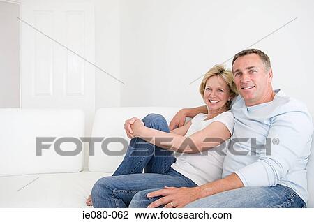 Mature couple resting on sofa View Large Photo Image Stock Image - Mature couple resting on sofa. Fotosearch