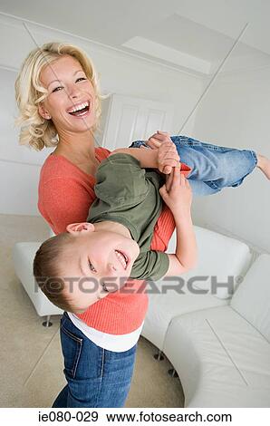 Mother and son playing in living room View Large Photo Image Stock Photo - Mother and son playing in living room. Fotosearch