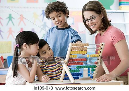 A teacher and children counting on an abacus View Large Photo Image Stock Image - A teacher and children counting on an abacus. Fotosearch