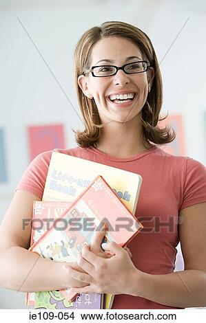 A teacher holding books View Large Photo Image Picture - A teacher holding books. Fotosearch