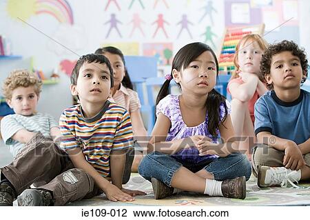 Stock Image - Children sitting on a floor. Fotosearch