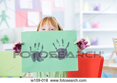 Girl holding up a painted hand print View Large Photo Image Stock Photo - Girl holding up a painted hand print. Fotosearch