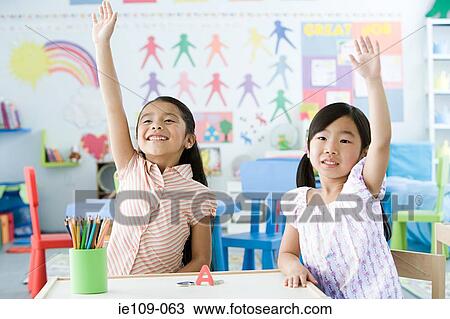 Two girls with their arms raised View Large Photo Image Stock Image - Two girls with their arms raised. Fotosearch
