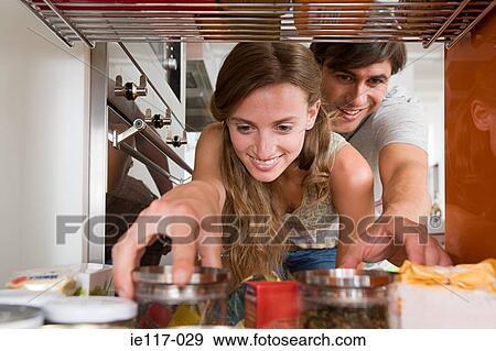 A couple reaching for jars of food View Large Photo Image Stock Photo - A couple reaching for jars of food. Fotosearch