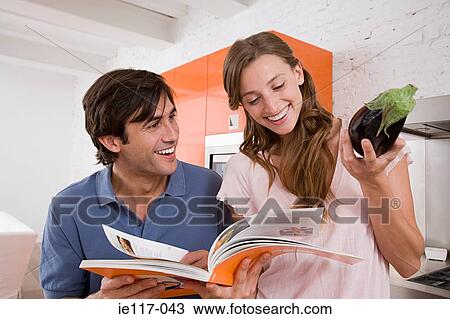 Stock Image - A couple reading a cookbook. Fotosearch