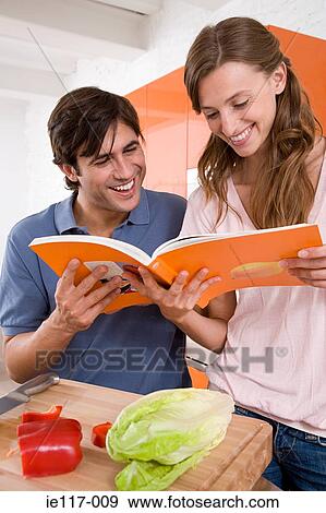 Stock Photo - A couple reading a cookbook. Fotosearch