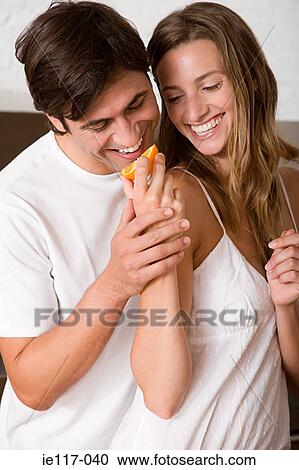 A woman feeding a man a slice of orange View Large Photo Image Stock Image - A woman feeding a man a slice of orange. Fotosearch