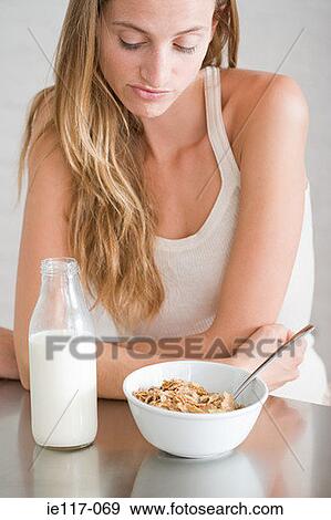 A woman looking at a bowl of cereal View Large Photo Image Stock Photo - A woman looking at a bowl of cereal. Fotosearch