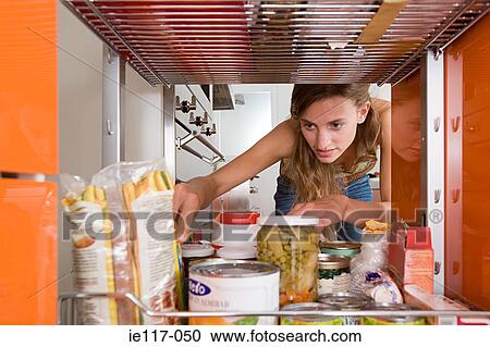 A woman reaching for a packet of food View Large Photo Image Stock Image - A woman reaching for a packet of food. Fotosearch