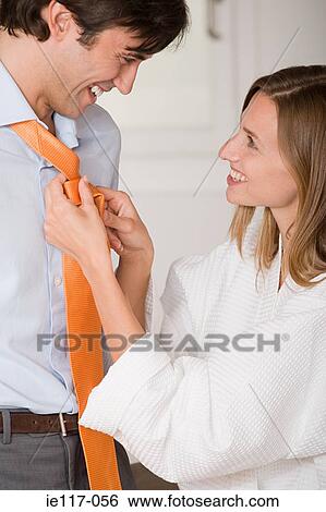 Stock Photograph - A woman tying a mans tie. Fotosearch