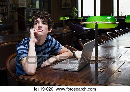 Boy daydreaming in library View Large Photo Image Stock Image - Boy daydreaming in library. Fotosearch