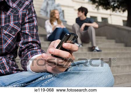 Boy text messaging on stairway View Large Photo Image Stock Photo - Boy text messaging on stairway. Fotosearch