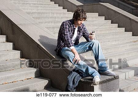 Boy text messaging on stairway View Large Photo Image Stock Photo - Boy text messaging on stairway. Fotosearch