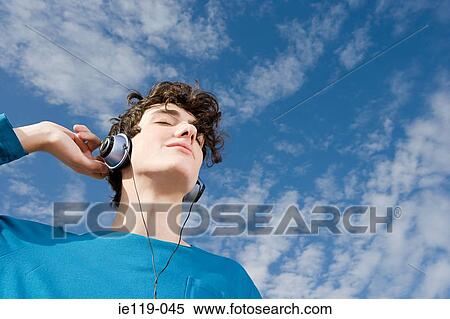 Teenage boy listening to music View Large Photo Image Stock Photography - Teenage boy listening to music. Fotosearch