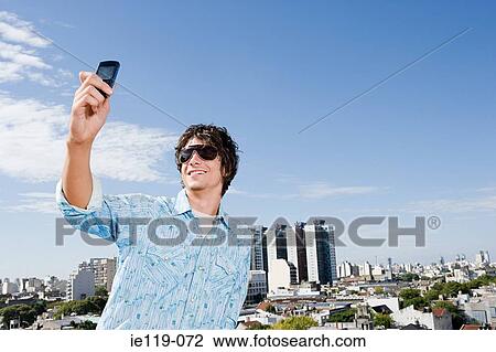 Teenage boy using a camera telephone View Large Photo Image Stock Image - Teenage boy using a camera telephone. Fotosearch