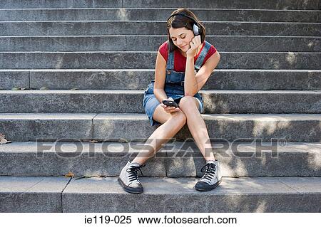 Teenage girl listening to an mp3 player View Large Photo Image Stock Photography - Teenage girl listening to an mp3 player. Fotosearch