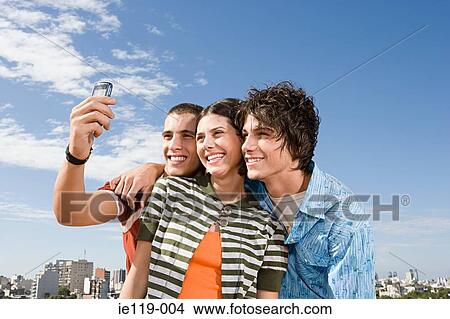 Teenagers posing for camera telephone View Large Photo Image Picture - Teenagers posing for camera telephone. Fotosearch