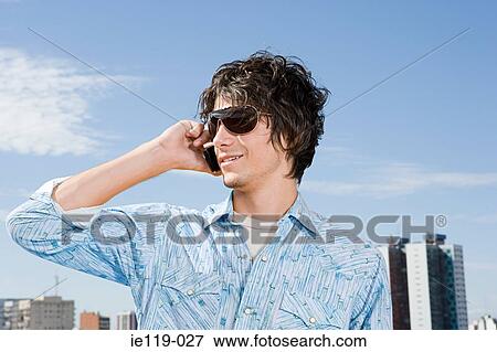 Stock Photo - Young man using a cellular telephone. Fotosearch