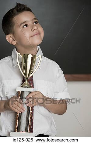 Boy holding a trophy View Large Photo Image Stock Photograph - Boy holding a trophy. Fotosearch