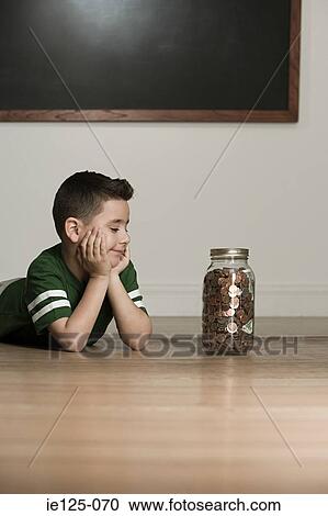 Boy looking at jar of money View Large Photo Image Stock Image - Boy looking at jar of money. Fotosearch