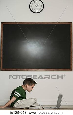 Boy looking at laptop View Large Photo Image Stock Photo - Boy looking at laptop. Fotosearch