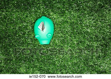 Stock Image - A dollar in a green piggy bank. Fotosearch