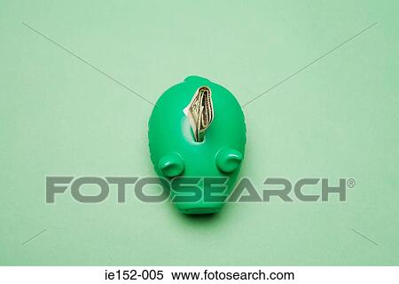 Stock Photography - A dollar in a green piggy bank. Fotosearch