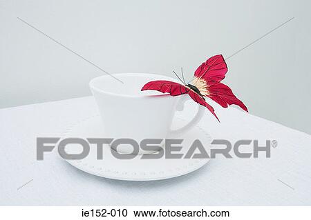 Stock Image - A fake butterfly on a cup. Fotosearch