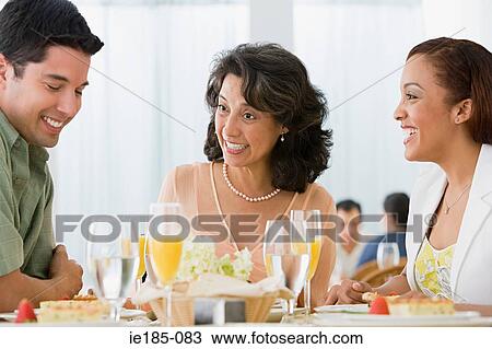 Stock Image - Family in restaurant. Fotosearch