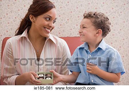 Son giving chocolates to mother View Large Photo Image Stock Image - Son giving chocolates to mother. Fotosearch
