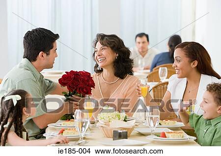Picture - Woman and family having meal. Fotosearch