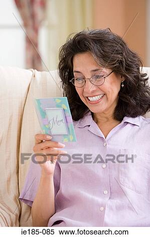 Stock Photography - Woman looking at greetings card. Fotosearch