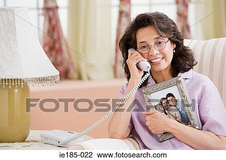 Woman on telephone with picture of family View Large Photo Image Stock Image - Woman on telephone with picture of family. Fotosearch