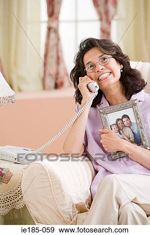 Woman on telephone with picture of family View Large Photo Image Stock Photo - Woman on telephone with picture of family. Fotosearch
