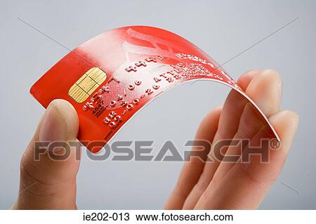 Stock Image - A person holding a credit card. Fotosearch